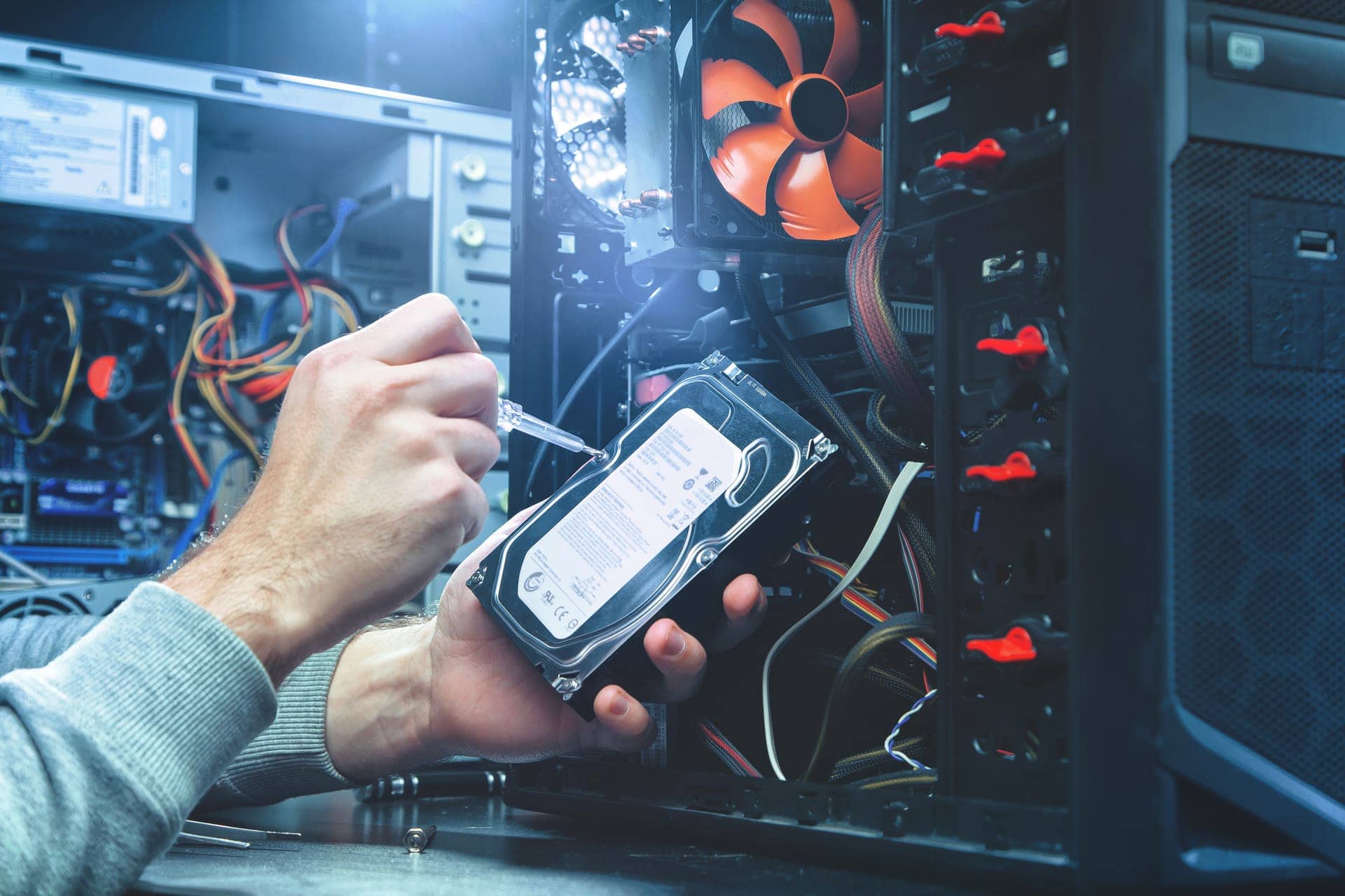 Engineer installing a hard drive in a desktop tower